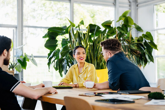 three office colleagues talking over coffee