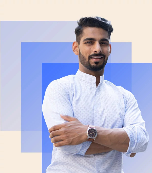 Young man wearing white shirt with his arms crossed across his chest. Behind him are 3 squares in different shades of blue