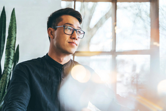 Portrait of a young handsome Asian entrepreneur, smiling and looking forward to the future innovations