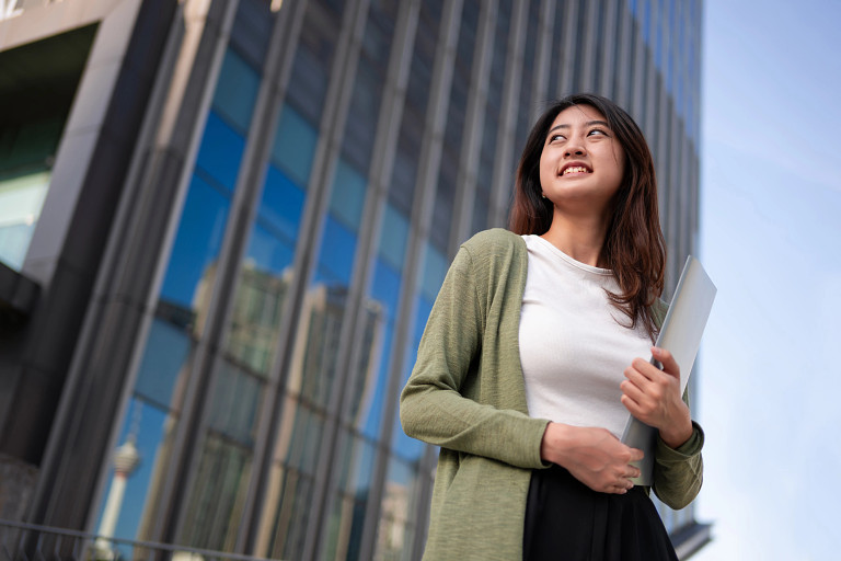 Student with laptop in financial district